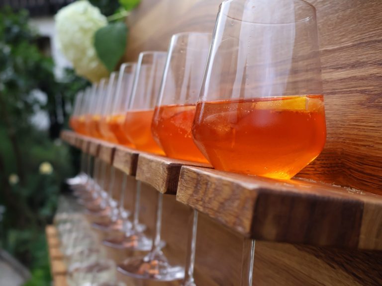Prosecco-Wand mit Sekt- und Aperolgläsern Prosecco-Wand mit gefüllten Gläsern Aperol Spritz und Sekt – elegantes Highlight für Hochzeiten und Sektempfänge